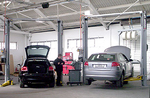 Audi workshop showing car lifted on 2 post hoist