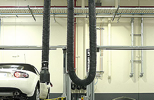 Auto workshop service bay with shared extraction unit between 2 bays