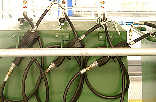 Lubrication dispensers in Suspended ceiling pit with hooks attached to custom made lubrication tanks