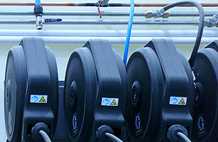 Lubrication reels with enclosures connected to high pressure lubrication lines