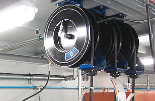 Lubrication hose reels mounted to roof of suspended ceiling workshop pit