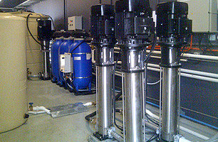 Facilities room with pressure tanks, pumps and water storage tanks